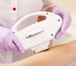 美容施術中の腕に高性能の機械を使用する様子