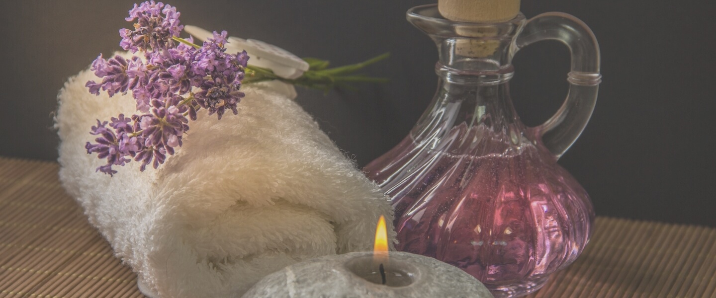 VALENTINE ROSE 渋谷店のイメージ写真。ふわふわの白いタオル、キャンドルの灯り、ピンクのフレグランスボトルが写っています。